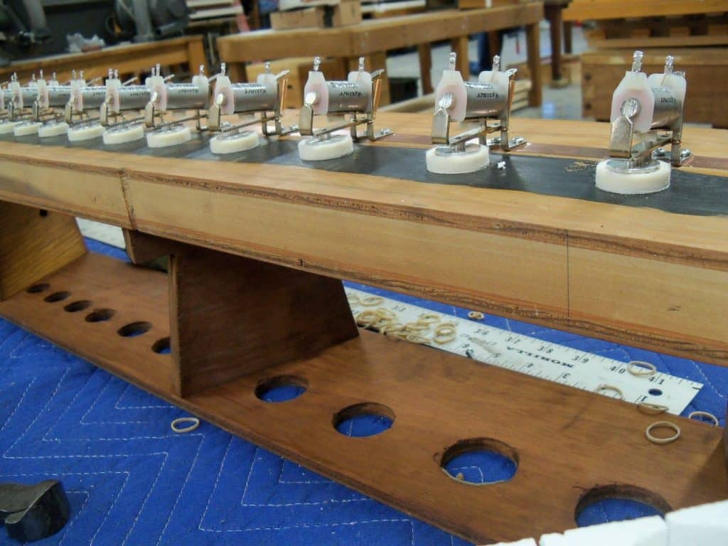 Toe board that holds the pipes of a pipe organ attached to a wind chest bottom board with magnets