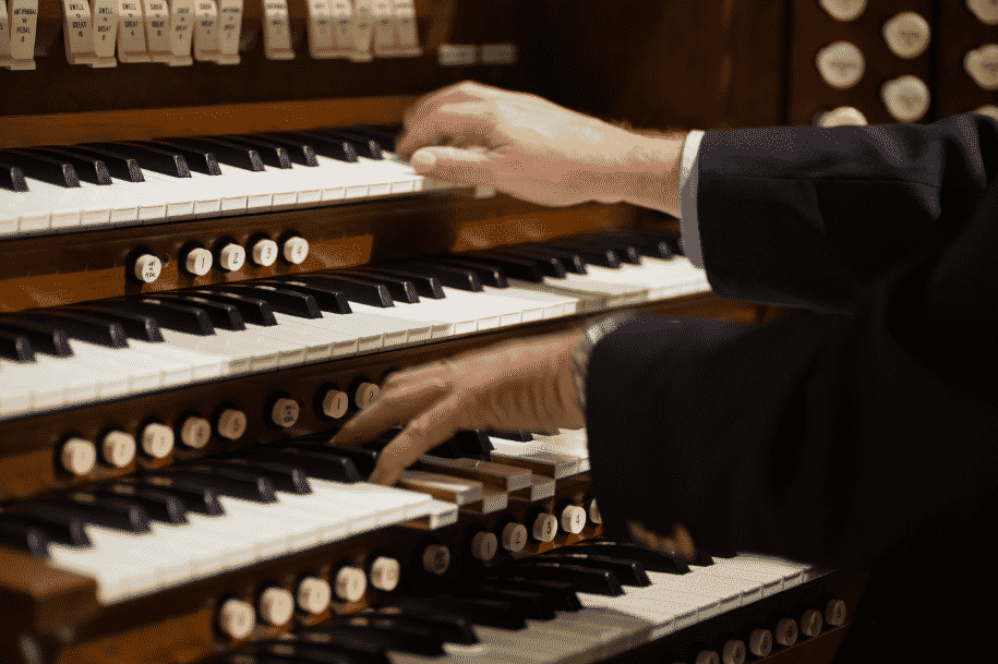 Organist playing on a four manual pipe organ console
