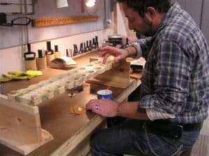 Technician Sean Estanek, Gluing on pouches at Leek Pipe Organ Company, Berea, OH