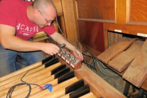 Technician Owen Rasmussen wiring the pipe organ pedal board on site