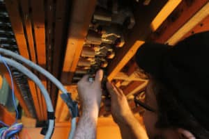 Technician Joseph Raville, inside the chambers removing Chest primaries for restoration back at the shop. Hill green and Lane Pipe Organ, Barberton, Ohio