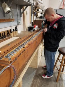 Leek workshop in Berea, Ohio, staff Wrapping wires to magnets of pipe organ wind chest