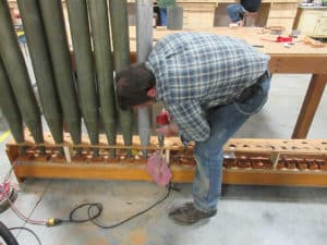 Technician adjusting pipe racks to ensure proper fit at Leek workshop in Berea, Ohio
