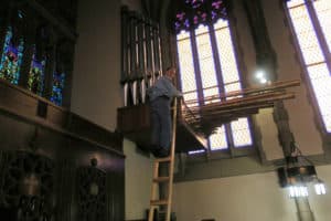 Organ builder James Leek examining the Trumpet en Charade pipe rank on site at Holy Trinity Lutheran Church, Akron Ohio