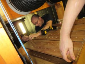 Technician Owen Rasmussen, inside the chambers reinstalling rebuilt pipe rack boards Hillgreen and Lane Pipe Organ, Barberton, Ohio