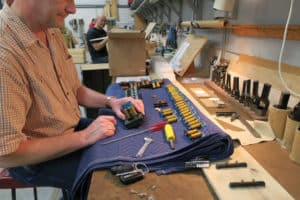Sr. Technician, John Jordon installing magnets on tilting tablet of pipe organ console name board, Berghaus Pipe Organ