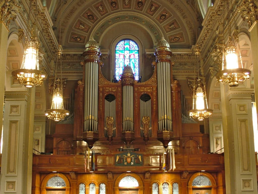 Ornate gilded pipe organ with gold leaf ornamentation on wood case