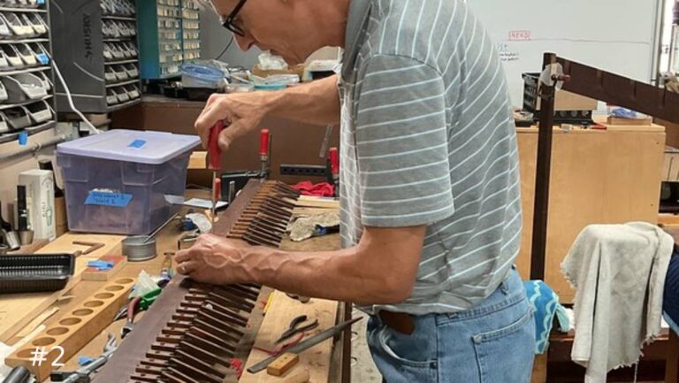 using a screwdriver on a long row of small wooden levers.