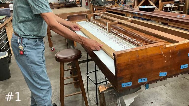 long wooden bar framework onto the white top surface of a large wood pipe organ mechanism.